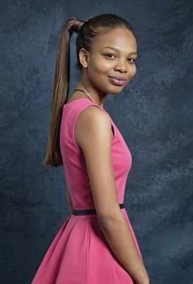 student with a sleek ponytail, in a solid bright pink minimalist dress, looking poised and graceful, murky blue yearbook background, mid shot photo 