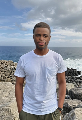 in a simple t-shirt standing atop a rocky outcrop, panoramic ocean view, hands in pockets