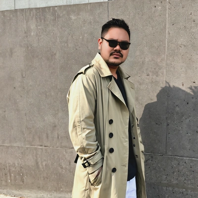 as a Kpop idol, wearing a fashionable oversized trench coat and sunglasses, standing by the airport wall