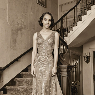 in a 1930s evening gown, standing on a grand staircase, with a faded sepia filter